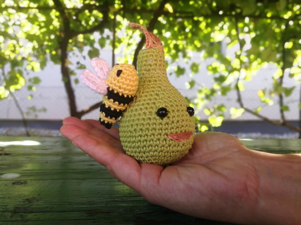 Heklana kruška sa pčelom na ruci izrađena amigurumi tehnikom